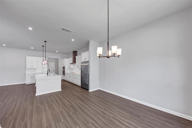 212 Birchwood Row, Canton, GA 30115 - kitchen with stainless steel fridge, open floor plan, baseboards, wall chimney exhaust hood, and recessed lighting