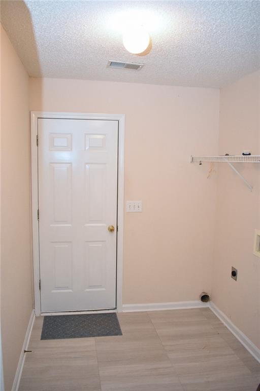 washroom with a textured ceiling and hookup for an electric dryer