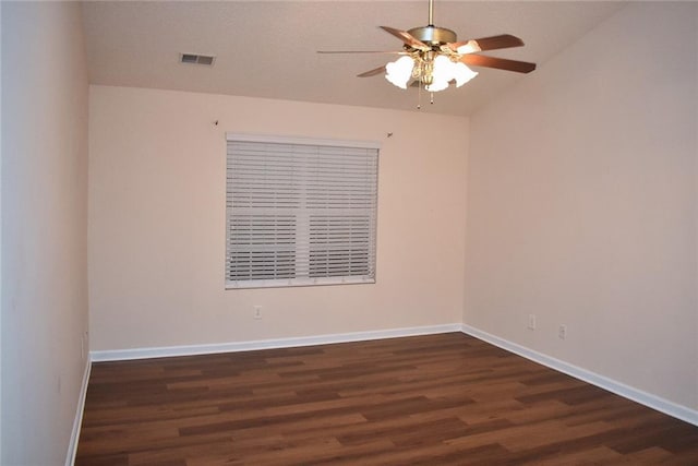 empty room featuring vaulted ceiling, ceiling fan, and dark wood-type flooring