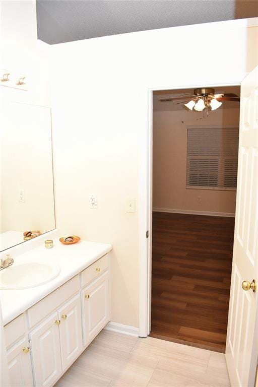 bathroom featuring wood-type flooring, vanity, and ceiling fan