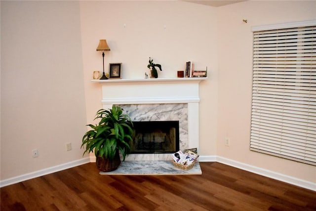 living room featuring a high end fireplace and hardwood / wood-style flooring