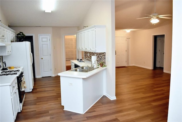 kitchen featuring white cabinets, dark wood-type flooring, kitchen peninsula, and gas range gas stove