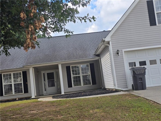 view of exterior entry featuring a garage and a yard