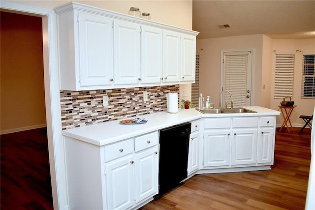 kitchen with tasteful backsplash, white cabinets, dishwasher, light wood-type flooring, and sink