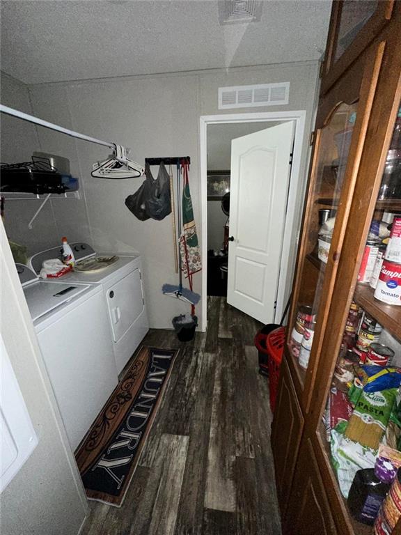 washroom featuring laundry area, independent washer and dryer, wood finished floors, and visible vents