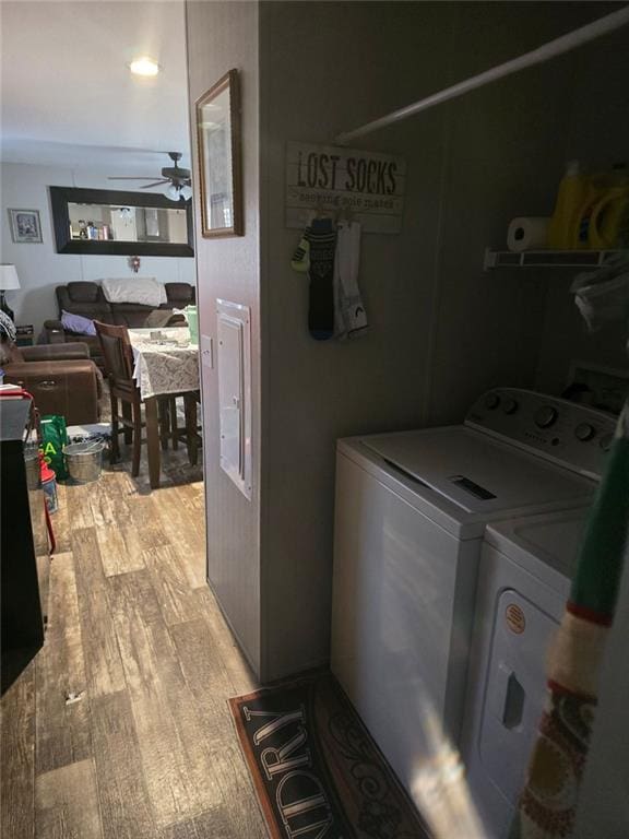 clothes washing area featuring a ceiling fan, laundry area, light wood finished floors, and washing machine and clothes dryer