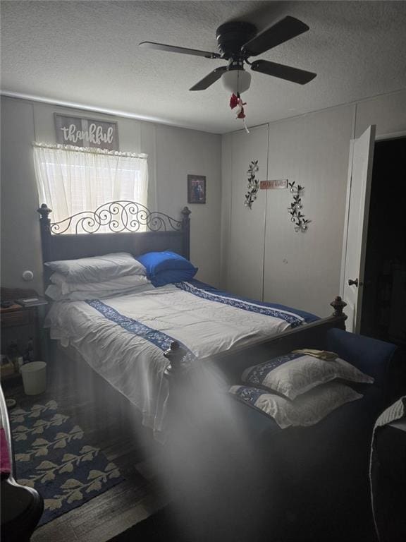 bedroom with ceiling fan and a textured ceiling