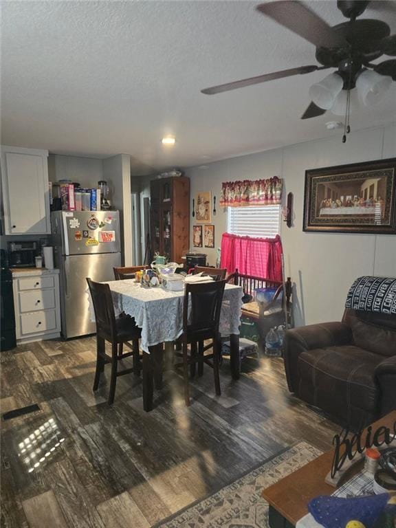 dining area featuring a ceiling fan, a textured ceiling, and wood finished floors