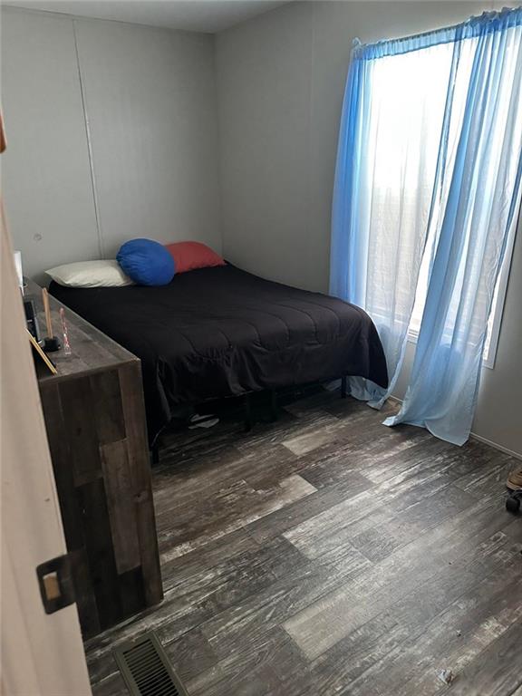 bedroom with visible vents and wood finished floors