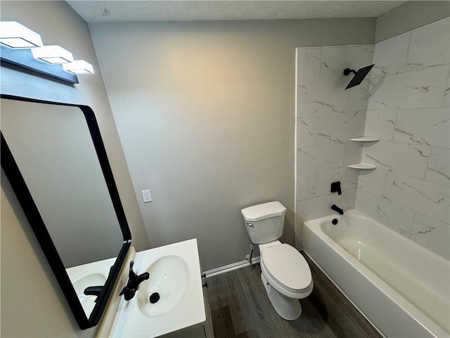 bathroom with wood finished floors, toilet, vanity, baseboards, and tub / shower combination