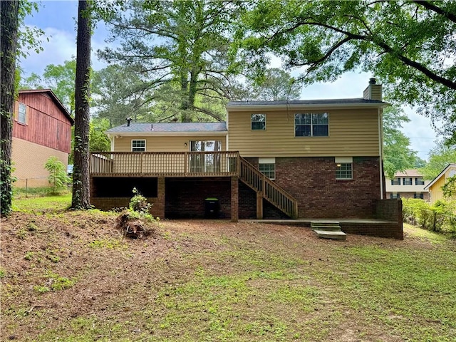 rear view of property featuring stairs, a wooden deck, a chimney, fence, and brick siding