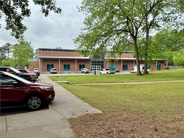 view of front of home with a front lawn and uncovered parking