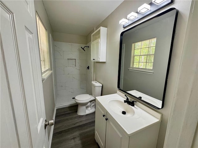 full bath featuring toilet, a stall shower, wood finished floors, and vanity