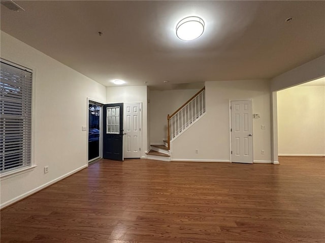 interior space with stairs, visible vents, wood finished floors, and baseboards