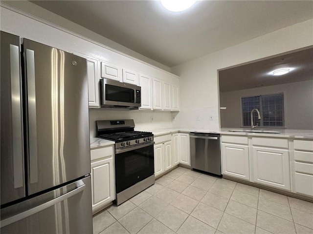 kitchen with light countertops, white cabinets, appliances with stainless steel finishes, and a sink