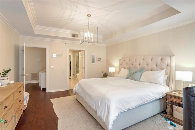 bedroom featuring an inviting chandelier, a tray ceiling, and dark hardwood / wood-style flooring