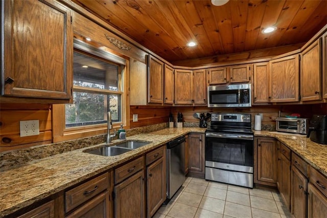 kitchen with light tile patterned floors, wooden ceiling, brown cabinetry, stainless steel appliances, and a sink