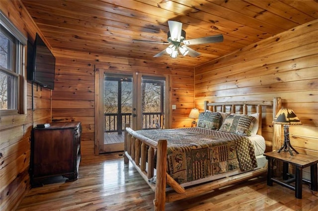 bedroom featuring access to outside, multiple windows, french doors, and hardwood / wood-style floors