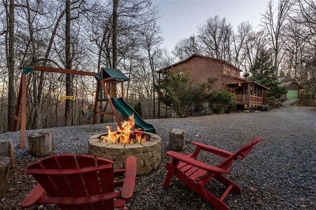 view of play area featuring a wooden deck and an outdoor fire pit