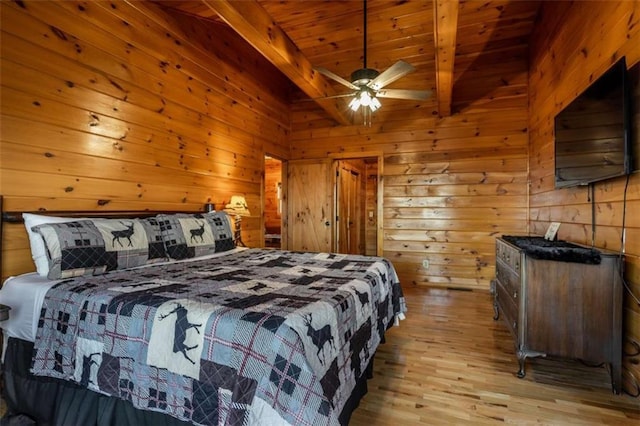 bedroom with wood ceiling, wooden walls, vaulted ceiling with beams, and light wood-style floors