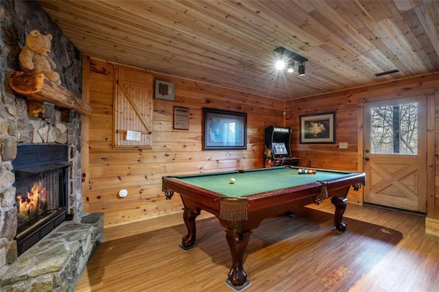 rec room featuring wood finished floors, wooden walls, wooden ceiling, a fireplace, and pool table