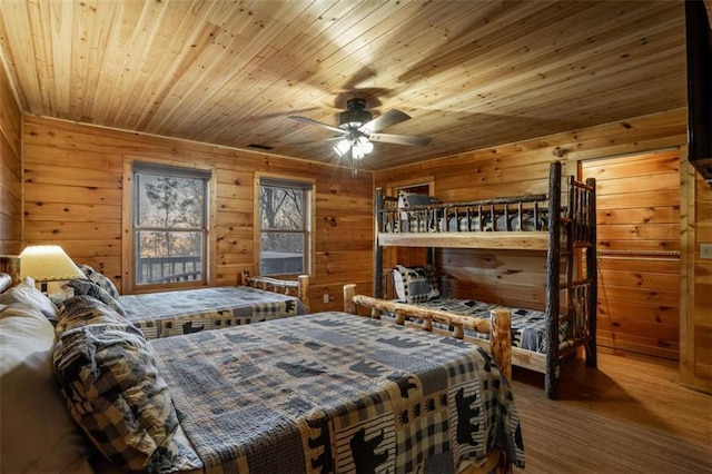 bedroom with wooden walls, wood ceiling, and wood finished floors