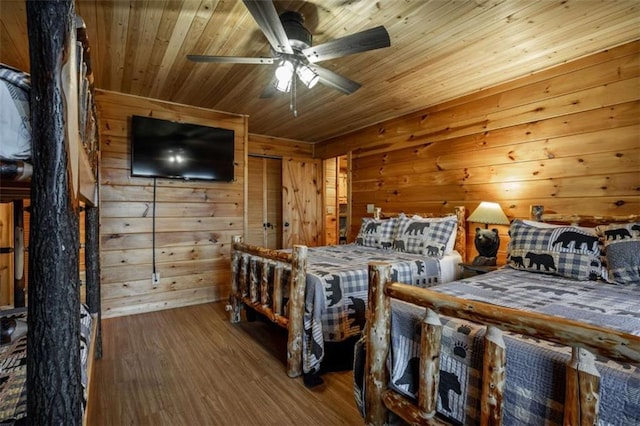 bedroom with wood finished floors, wooden walls, wooden ceiling, and a ceiling fan