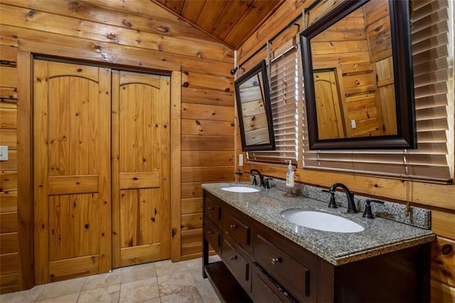 bathroom with a sink, wooden walls, wooden ceiling, and double vanity