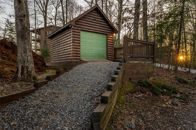 exterior space with an outbuilding, gravel driveway, and a garage