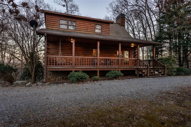 log cabin with a porch and a chimney