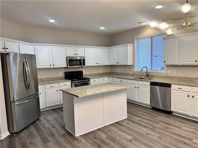 kitchen with white cabinetry, sink, a center island, stainless steel appliances, and dark wood-type flooring