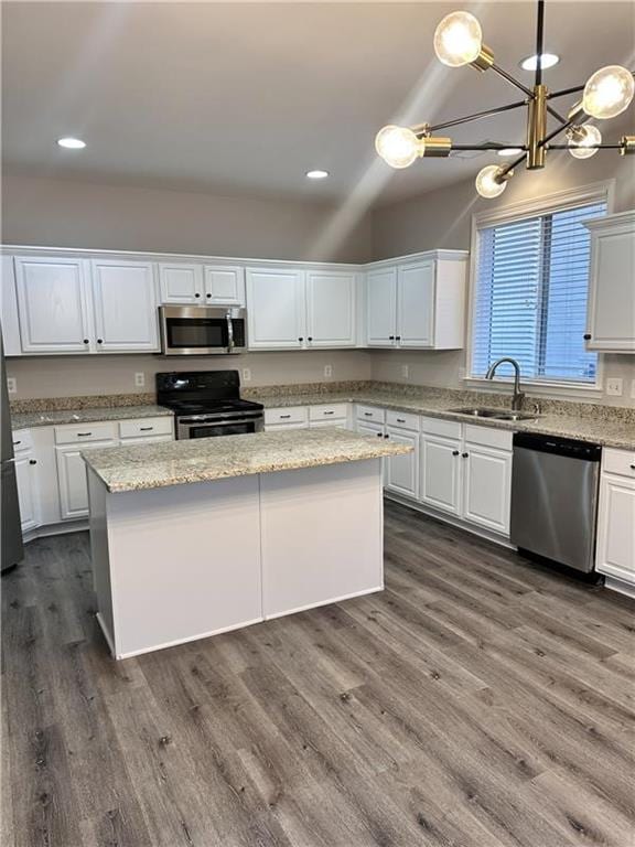 kitchen featuring stainless steel appliances, sink, a kitchen island, and white cabinets