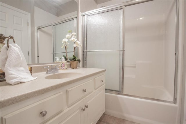 bathroom featuring tile patterned flooring, combined bath / shower with glass door, and vanity