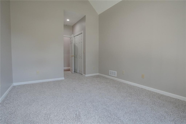 unfurnished room featuring lofted ceiling, recessed lighting, light colored carpet, visible vents, and baseboards