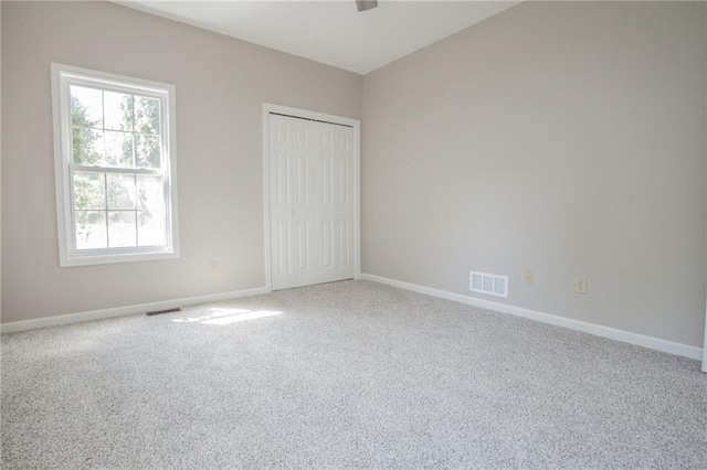 unfurnished bedroom with carpet, visible vents, and baseboards