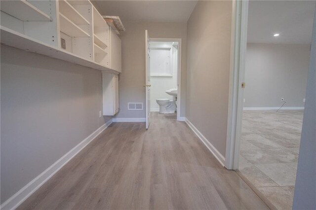 interior space featuring baseboards, visible vents, and light wood-style flooring