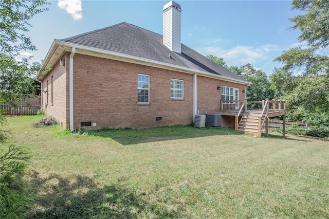 back of property with crawl space, brick siding, a lawn, and a chimney