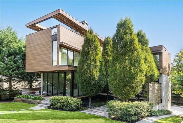 rear view of property with a sunroom and a yard