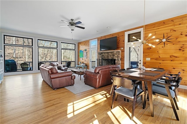 57 Shaggy Maple Ln, Big Canoe, GA 30143 - living room featuring a ceiling fan, light wood finished floors, a stone fireplace, crown molding, and wood walls