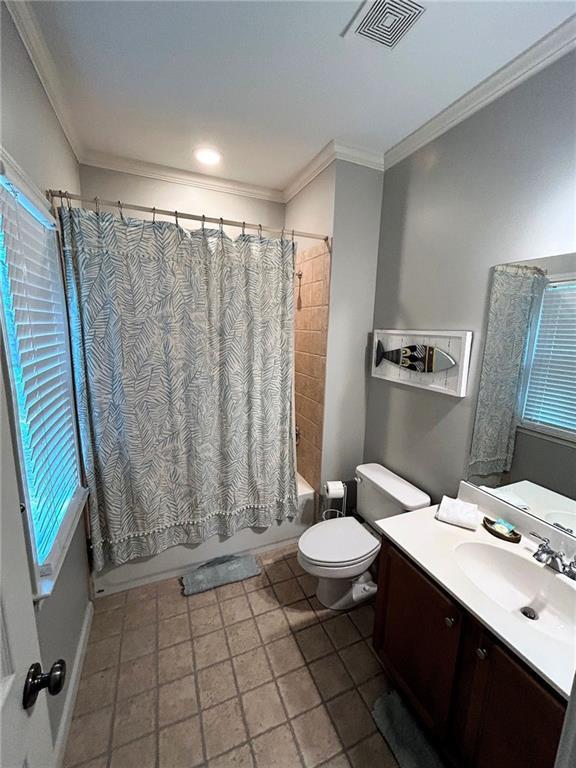 bathroom with toilet, vanity, visible vents, ornamental molding, and shower / bathtub combination with curtain