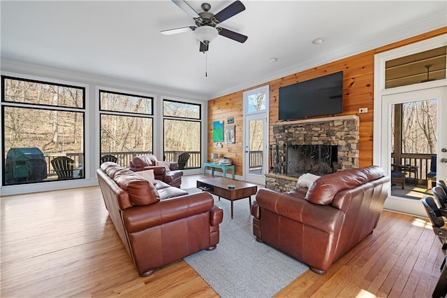 57 Shaggy Maple Ln, Big Canoe, GA 30143 - living area featuring crown molding, light wood-style floors, a fireplace, a ceiling fan, and wooden walls