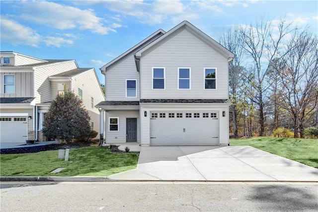 view of front of house with an attached garage, a front lawn, and concrete driveway