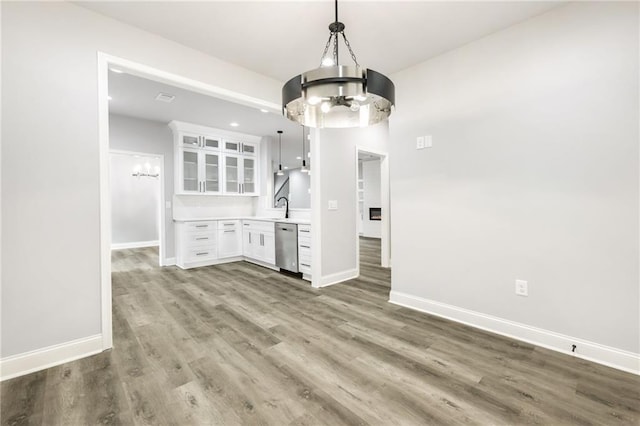 interior space with a notable chandelier, a sink, baseboards, and wood finished floors