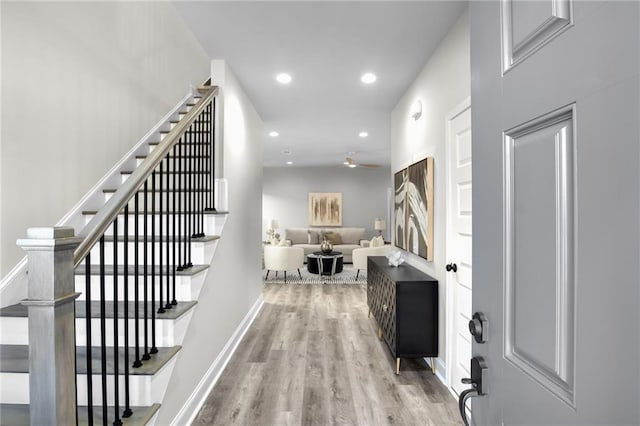 foyer entrance with baseboards, wood finished floors, and recessed lighting