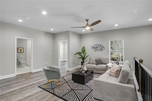 living area with baseboards, wood finished floors, and recessed lighting