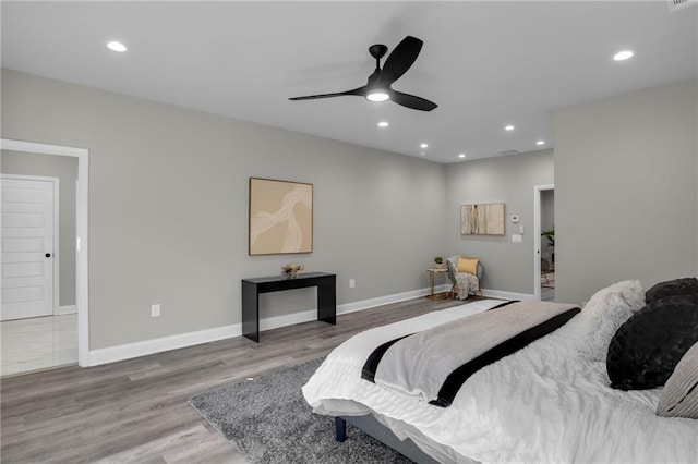 bedroom with baseboards, wood finished floors, and recessed lighting