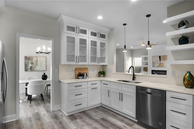 kitchen featuring white cabinets, pendant lighting, stainless steel appliances, open shelves, and a sink