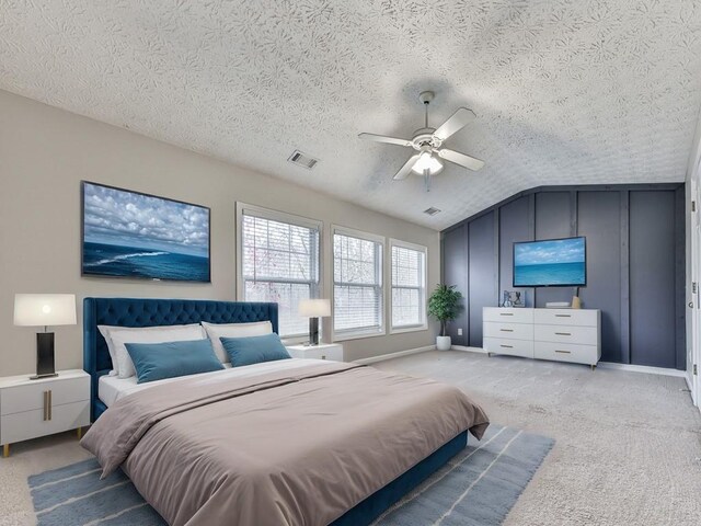 carpeted bedroom with a textured ceiling, ceiling fan, and lofted ceiling