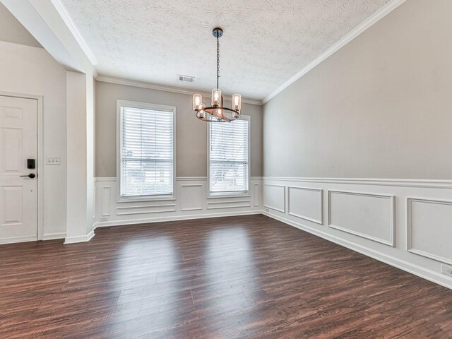 unfurnished dining area featuring dark hardwood / wood-style floors, a textured ceiling, and a notable chandelier