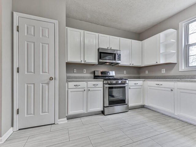 kitchen featuring white cabinetry, a textured ceiling, and appliances with stainless steel finishes